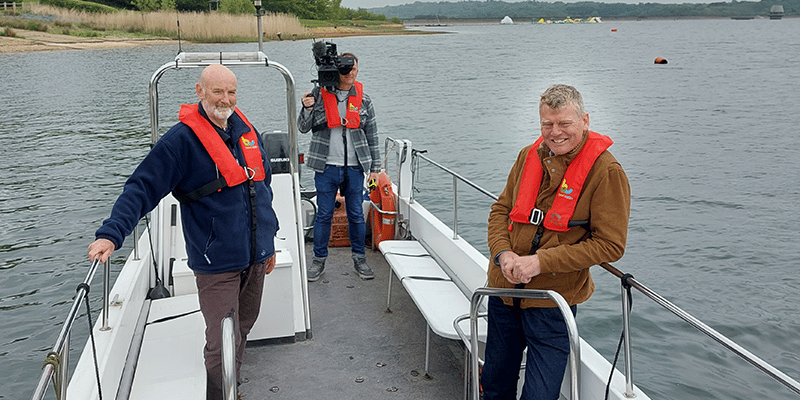Cameraman and two men on a boat